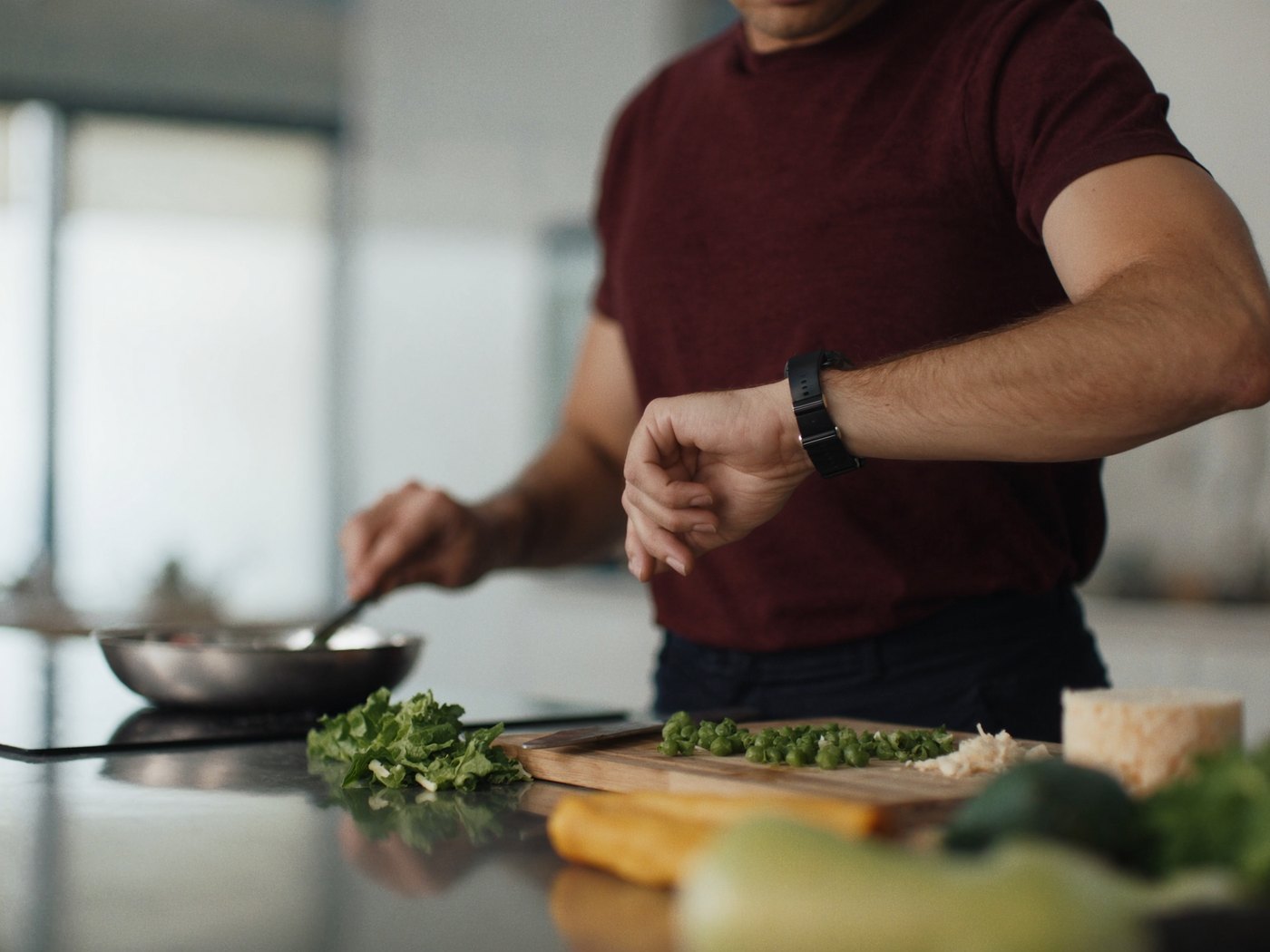 Man cooking and checking his Apple Watch for his protein target