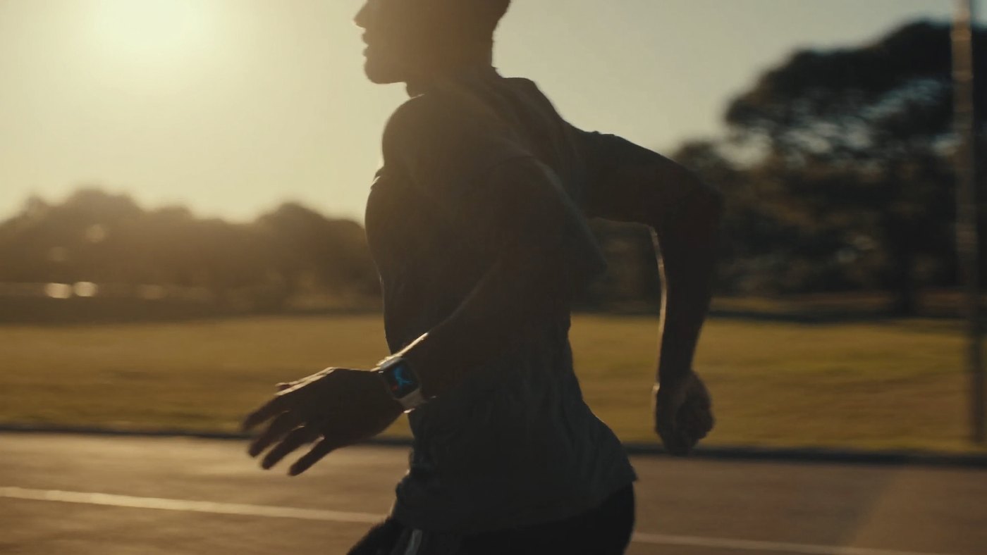 Runner outdoors at sunset wearing an Apple Watch that tracks the workout