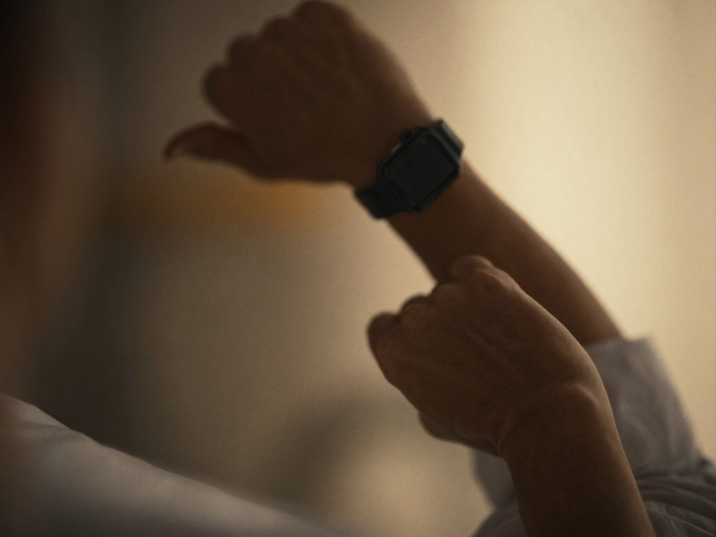 Person raising their wrist to check Apple Watch recovery and sleep score in the morning