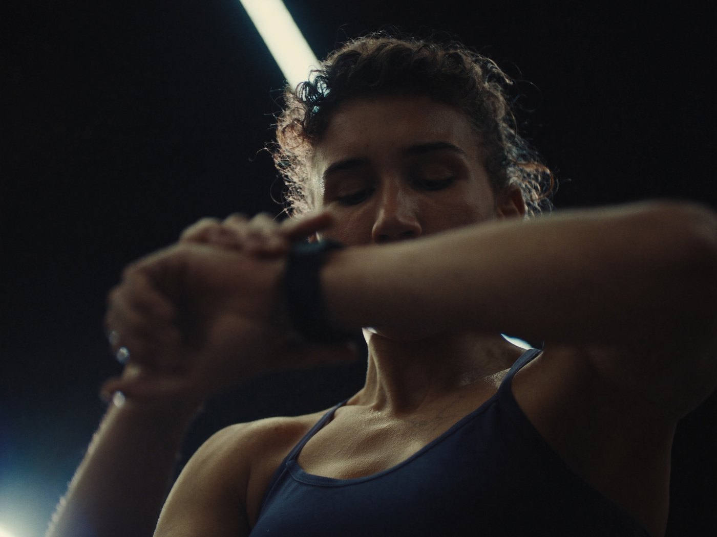 Athlete checking heart rate and strain on an Apple Watch during a gym workout