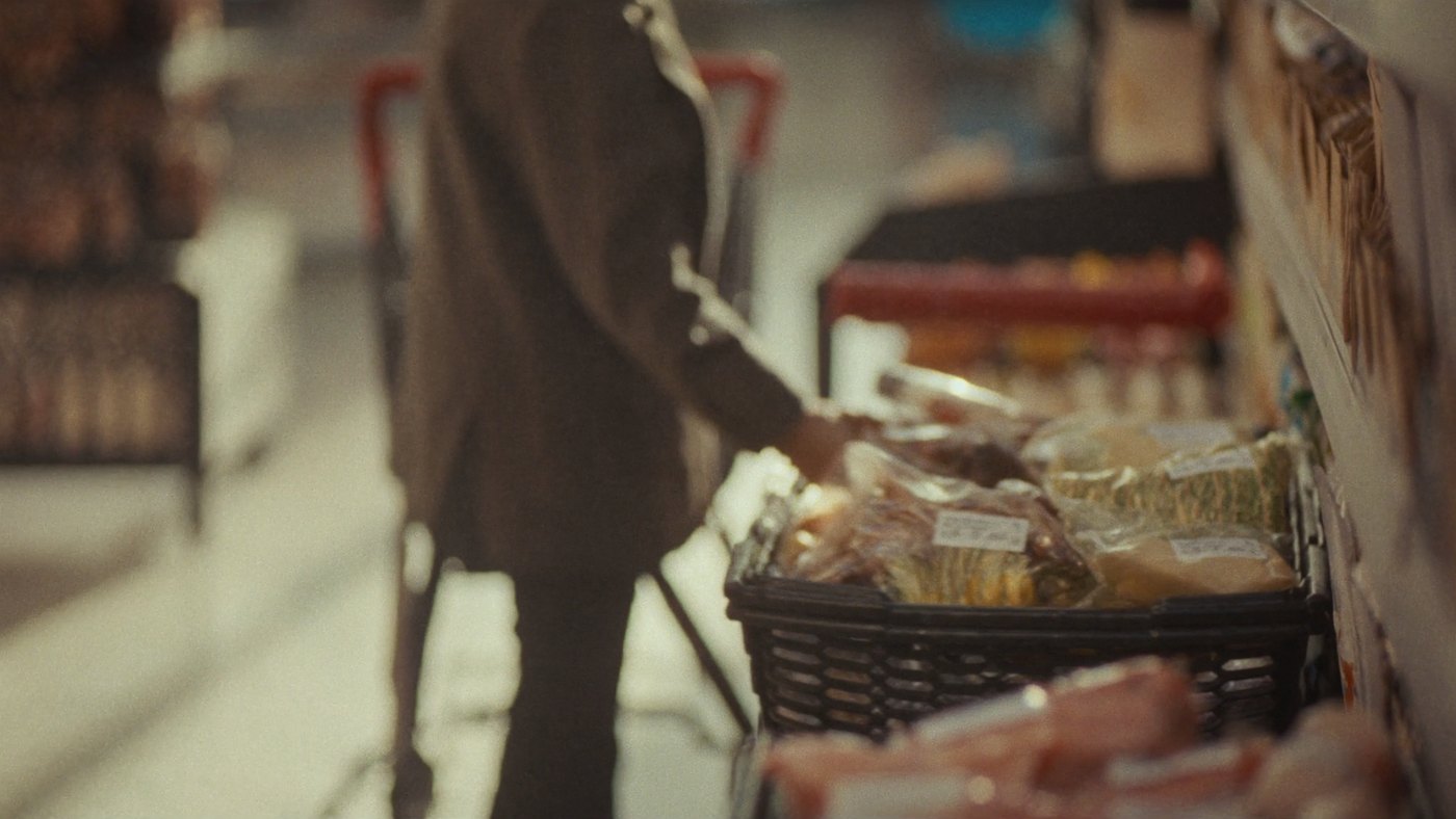 A person placing a chosen grocery product into a shopping basket