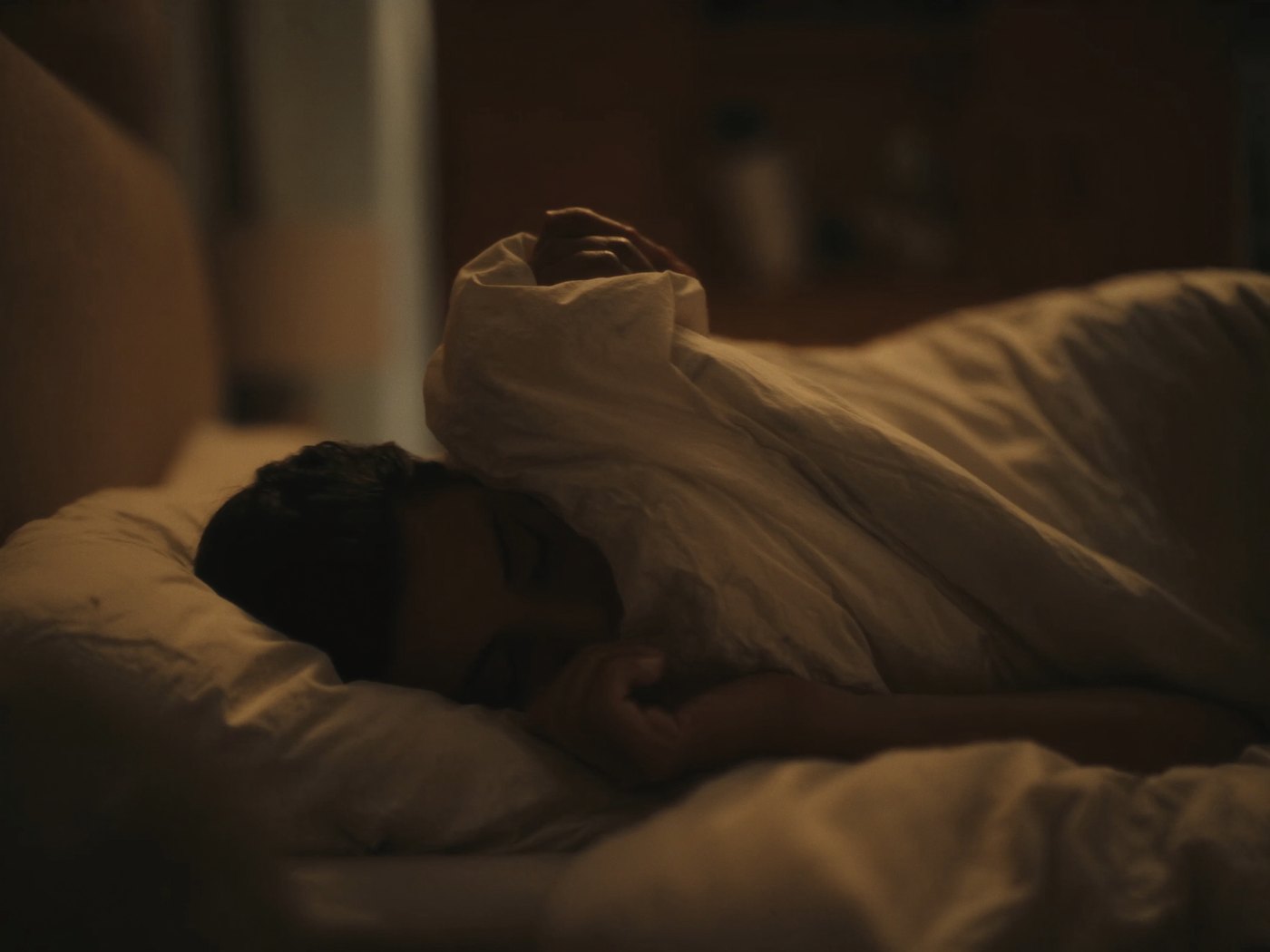 Person sleeping peacefully in a dimly lit bedroom at night