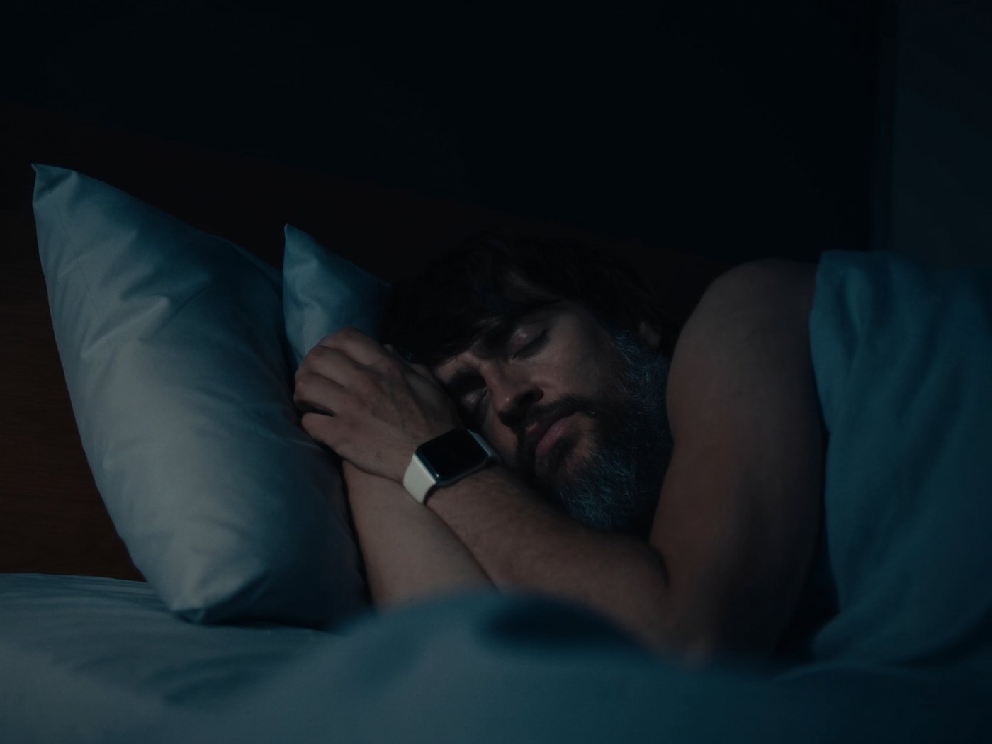 Person sleeping with a smartwatch on their wrist tracking sleep overnight