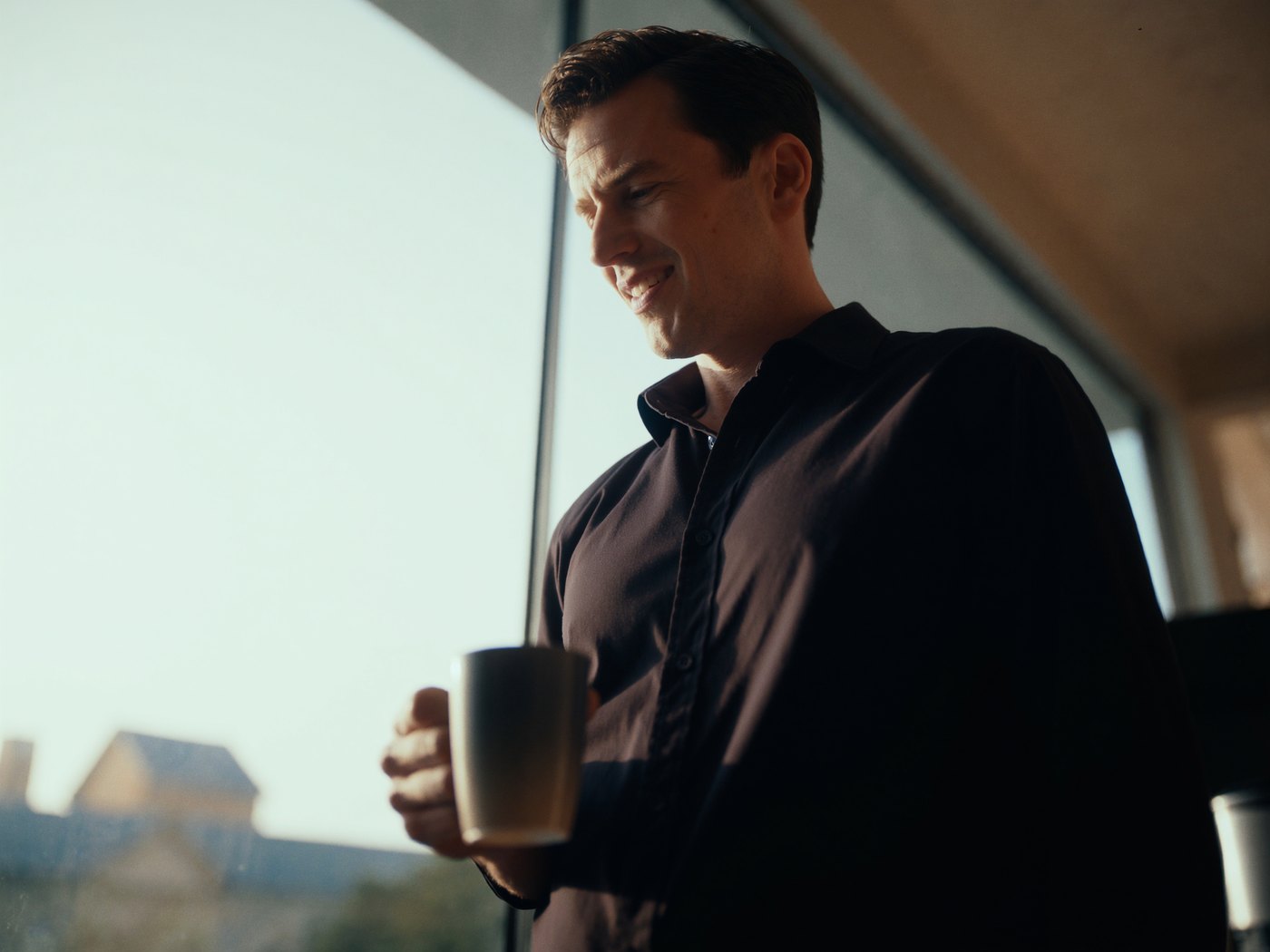 Refreshed person by a sunlit window with morning coffee